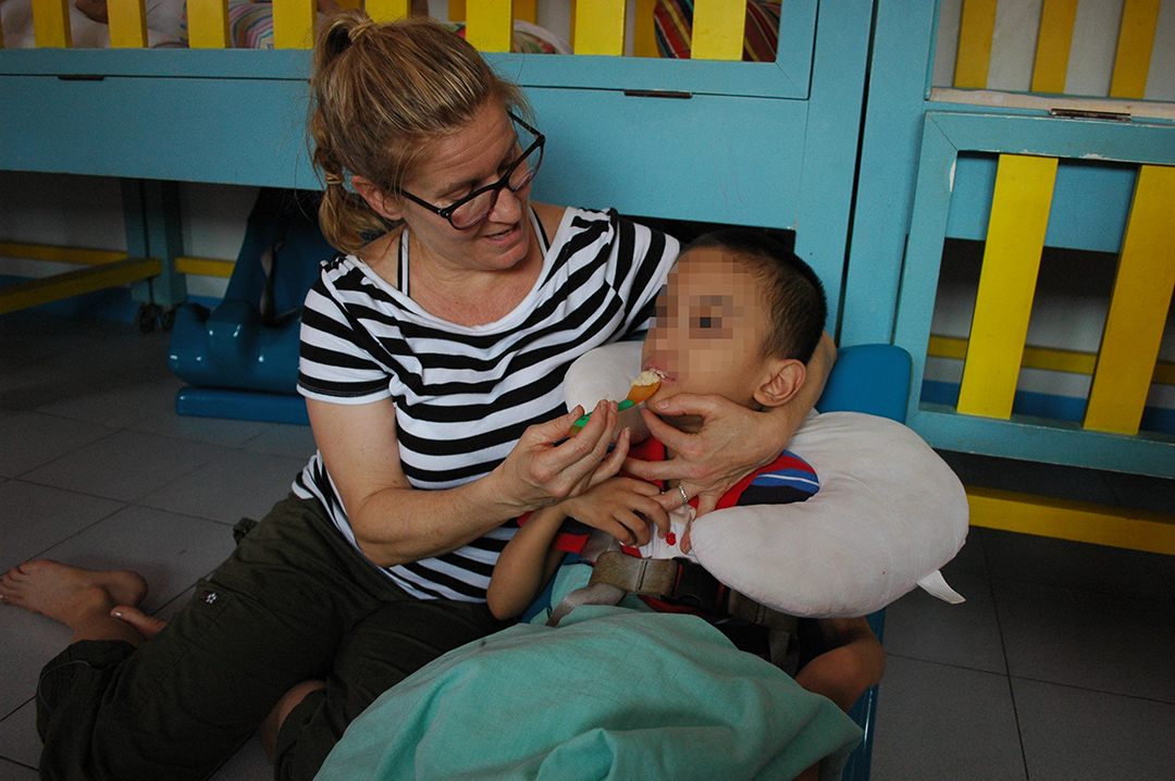 One of Holt's feeding specialists, Rae Catt, properly positions a child to be able to eat.